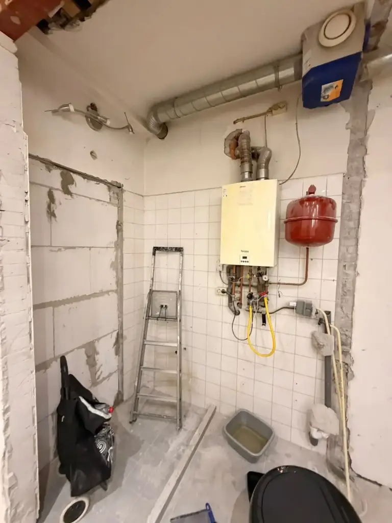 Nieuw opgehangen cv-ketel met expansievat en leidingwerk in een technische ruimte.