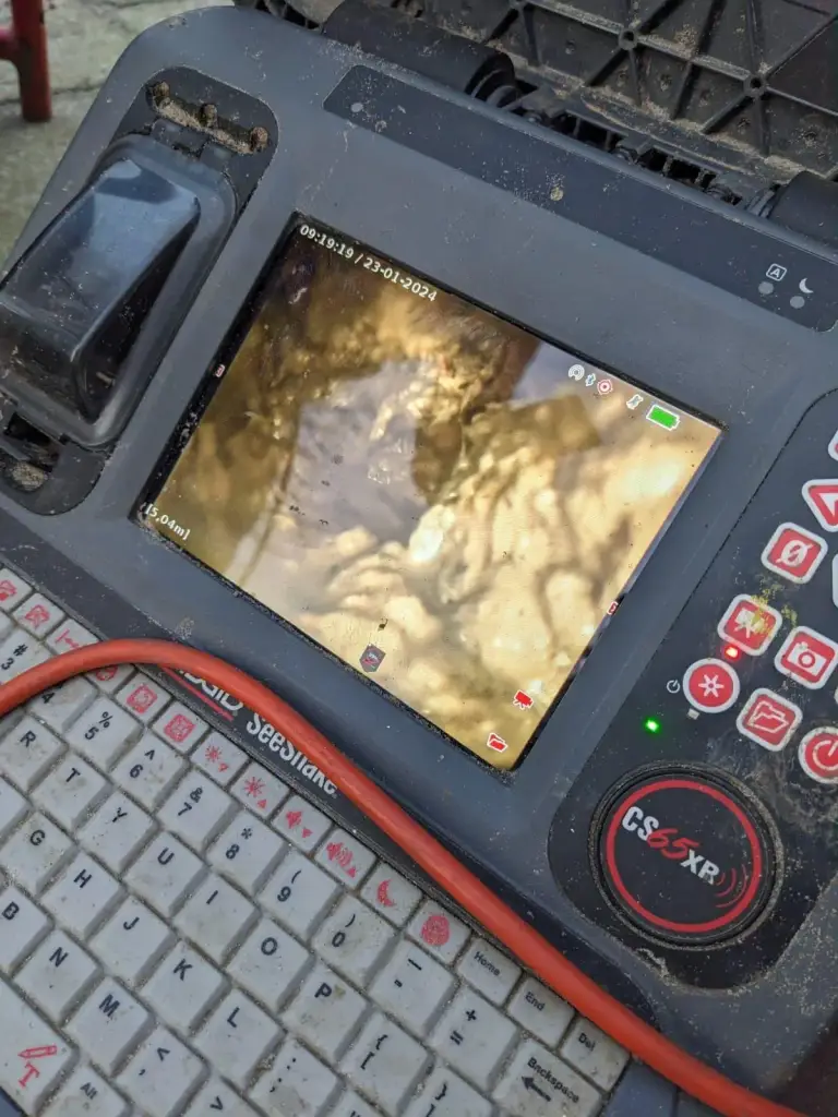 Bedieningspaneel van een rioolinspectiecamera met camerabeeld van de binnenkant van een riolering.